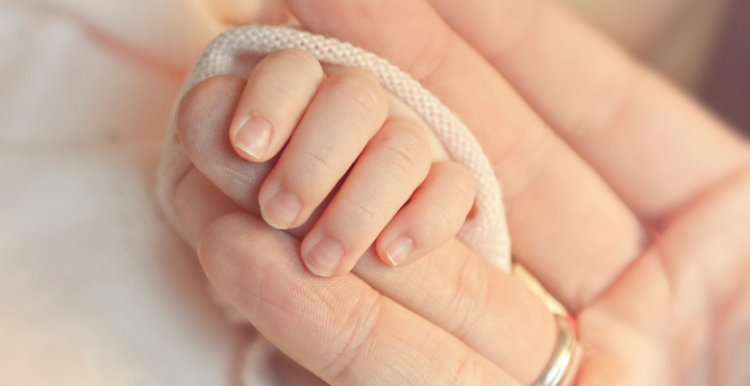 A person holding a new born baby hand