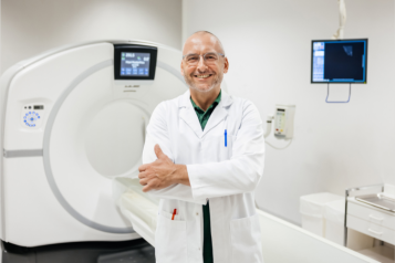 Male doctor standing by a MRI scanner