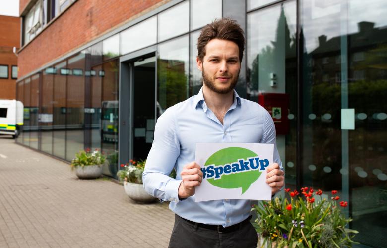 Man holding healthwatch speak up sign