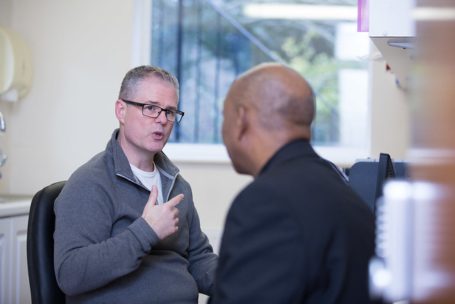 White man and black man seated and animated in conversation