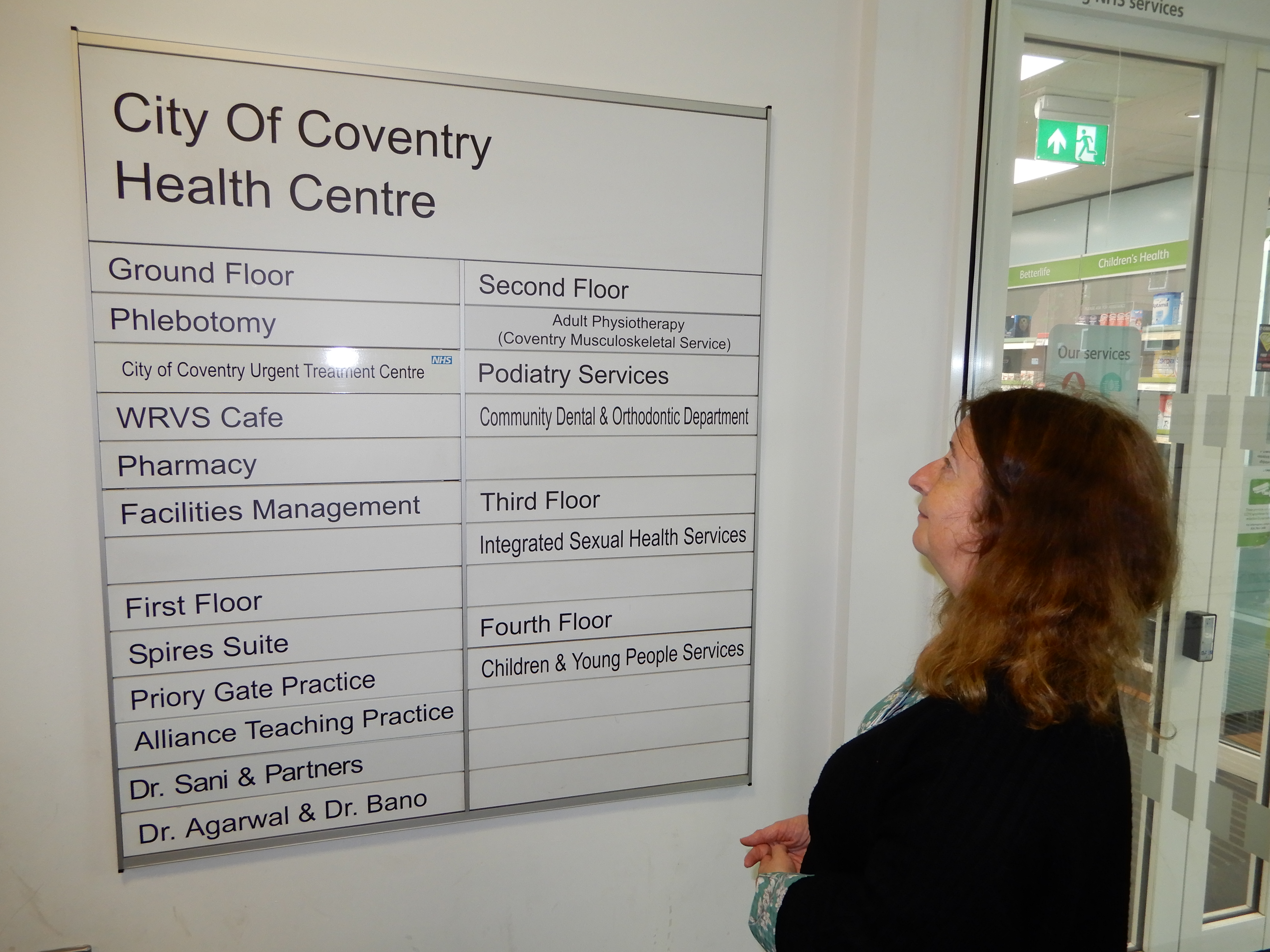 Woman looking at wall signs in health centre