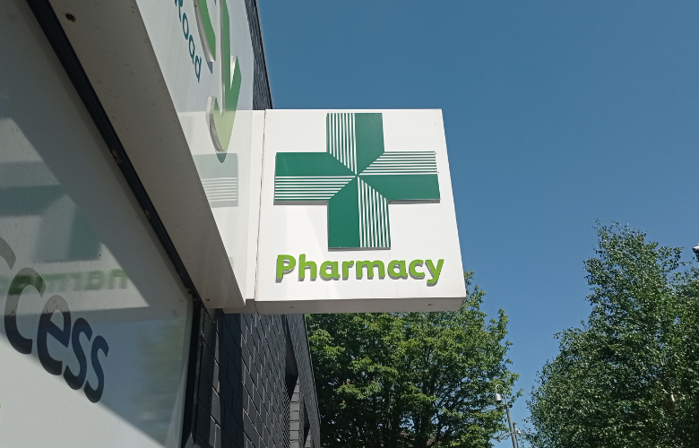 Image of a pharmacy sign with a green cross