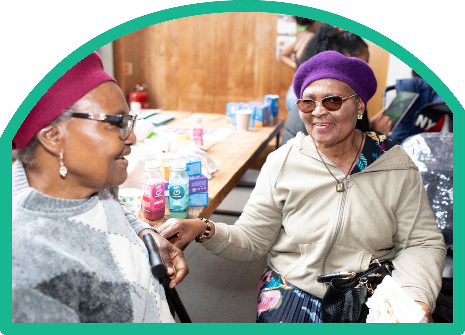 Two elderly ladies sitting together talking at an event