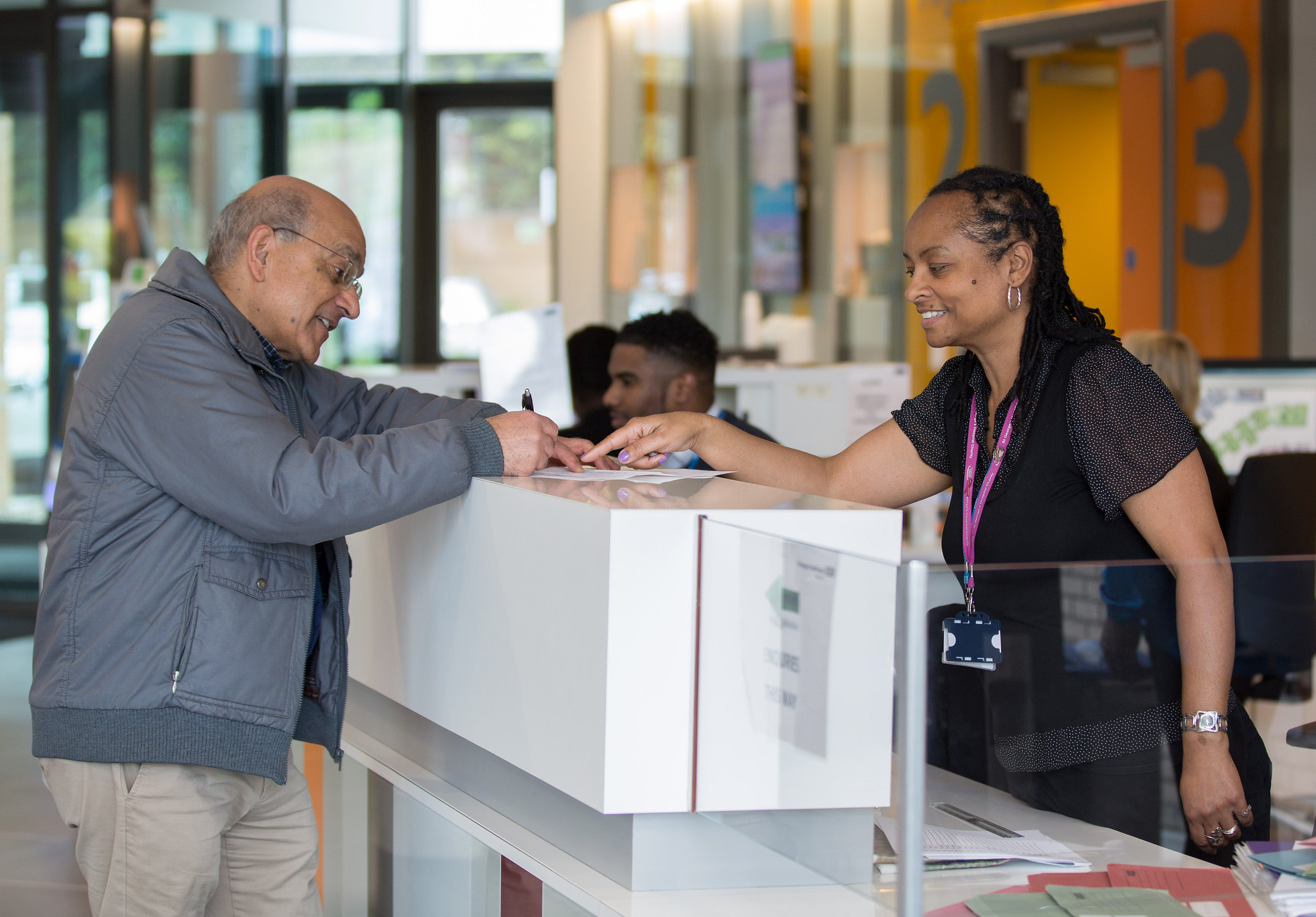 Male patient speaking to a receptionist