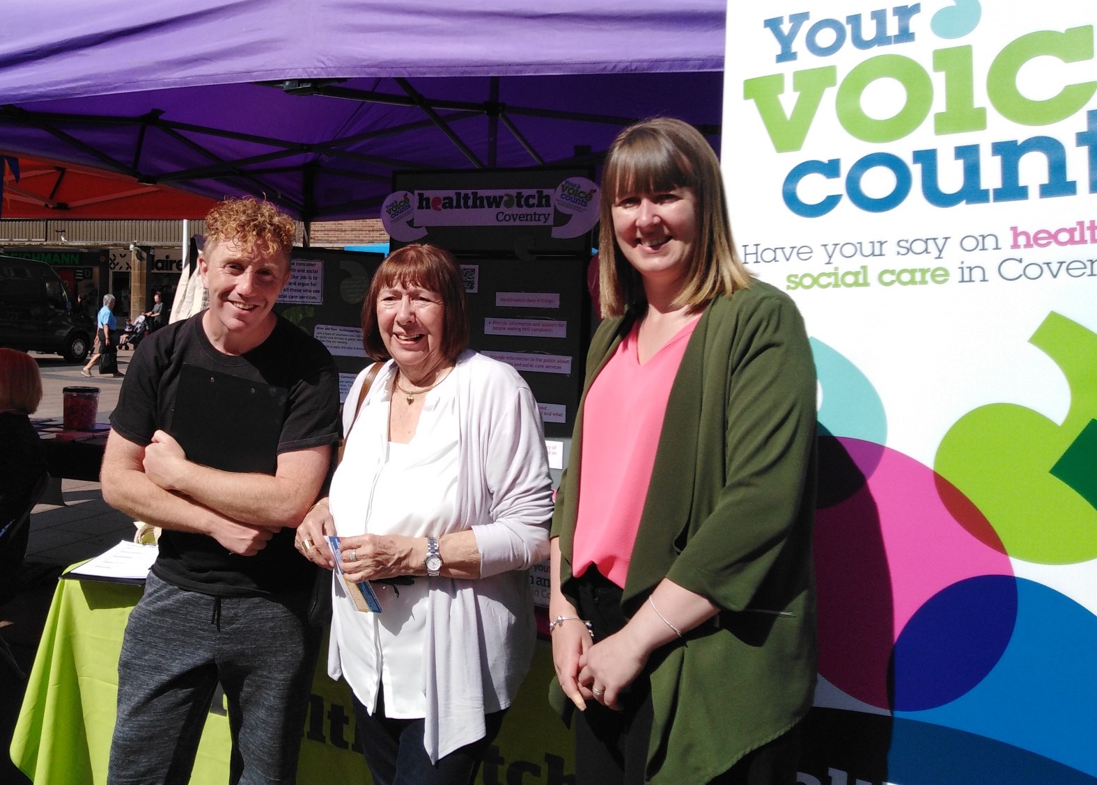 man and two women standing by Healthwatch information stall