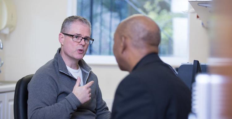 Two men seated and in conversation