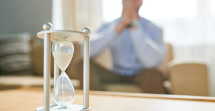 Man sitting on a sofa watching a sand timer