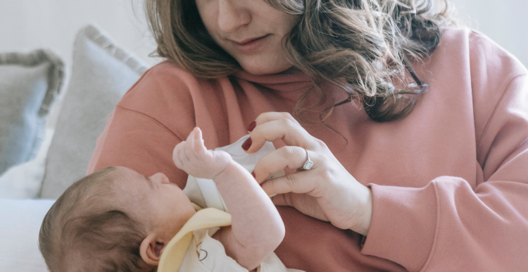 A lady feeding her baby with a bottle