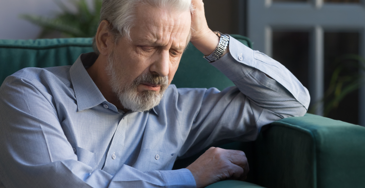 Elderly man sat down on a sofa