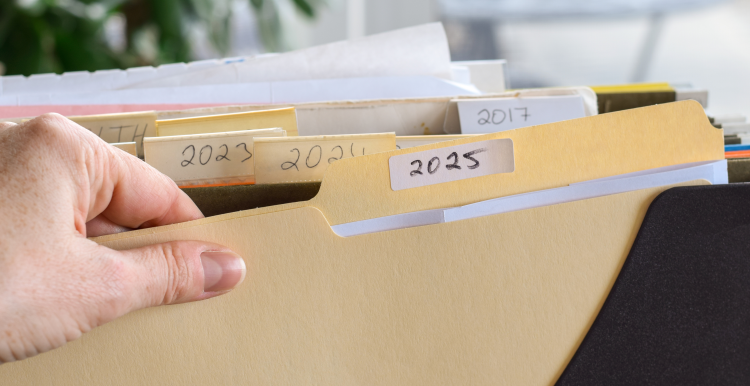 A person's hand grabbing a paper file