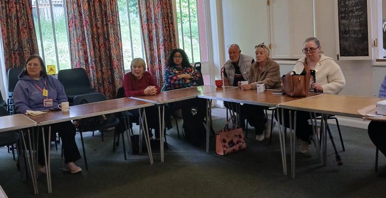 A group of women and men sitting round a table attending a focus group