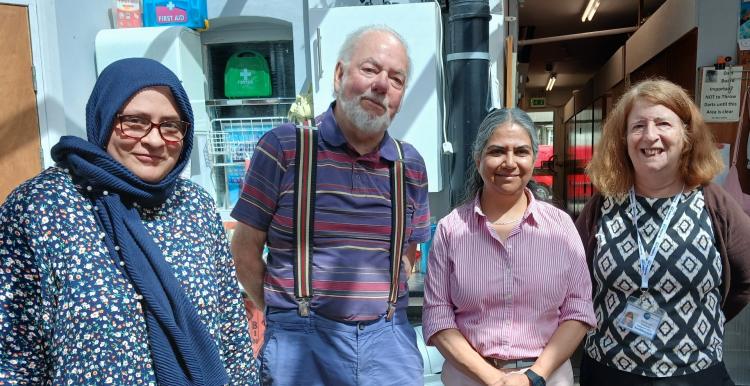 Image of four people standing together, 3 women and 1 man