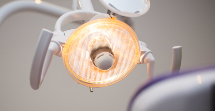 Image of the back of a chair in the dentist looking up at the dentist's lights.