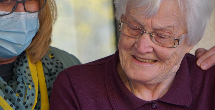 Elderly lady looking at phone with family member Elderly lady looking at phone with family member