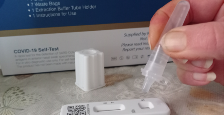Processing a lateral flow test An image of a hand processing a lateral flow test