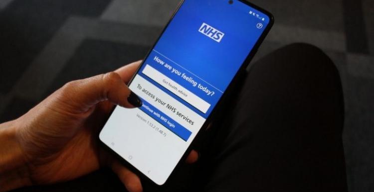 NHS Covid-19 pass image Picture of hand holding a mobile phone