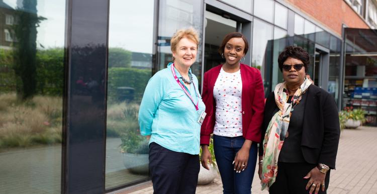 Three women standing outside a hospital entrance