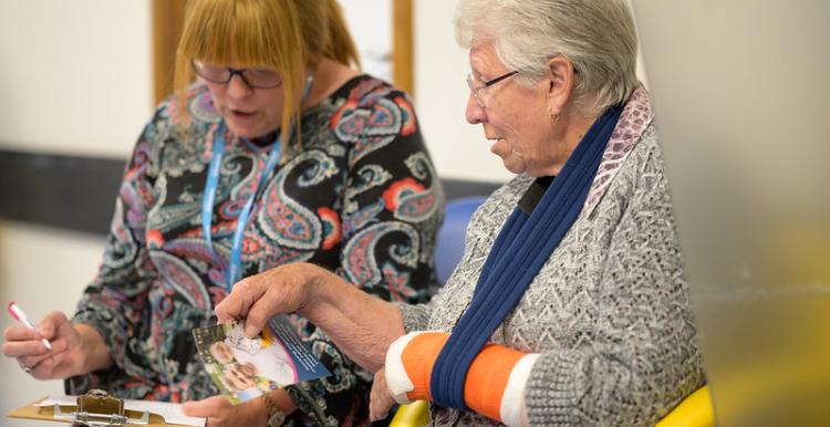 Two women sat down together going through a questionnaire