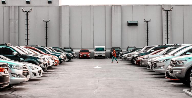 A lady walking through a car park