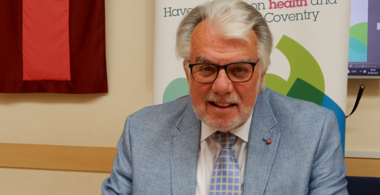 Picture of Stuart Linnell sitting at a meeting table and smiling