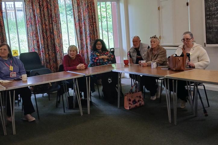 A group of women and men sitting round a table attending a focus group
