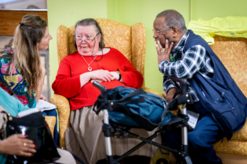 Three people sat talking together