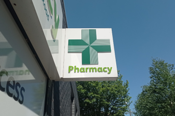 Image of a pharmacy sign with a green cross