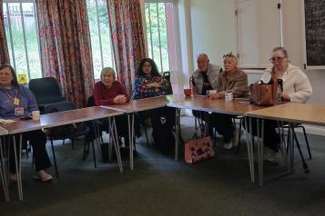 A group of women and men sitting round a table attending a focus group
