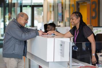 Male patient speaking to a receptionist