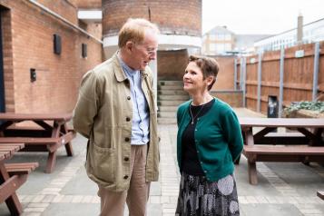 A man and a woman smiling and talking to each other