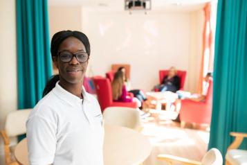 Black female care worker smiling at the camera