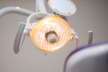 Image of the back of a chair in the dentist looking up at the dentist's lights.