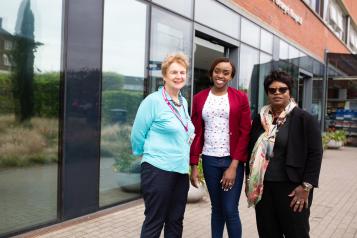 Three women standing outside a hospital entrance