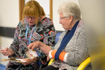 Two women sat down together going through a questionnaire