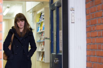 Woman alone in dark coat looking downwards