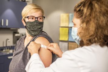 Women just after having COVId-19 jab having plaster stuck on arm 