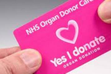 Two_hands_holding_organ_donor_card