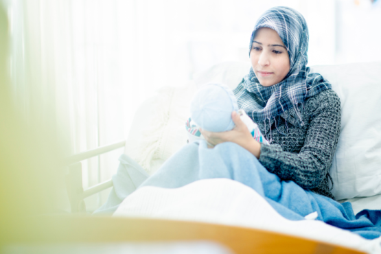A lady with her new born baby in a hospital bed