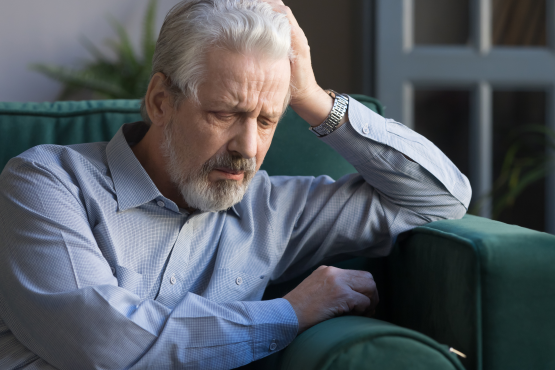 Elderly man sat down on a sofa