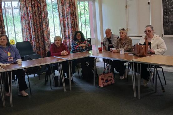 A group of women and men sitting round a table attending a focus group