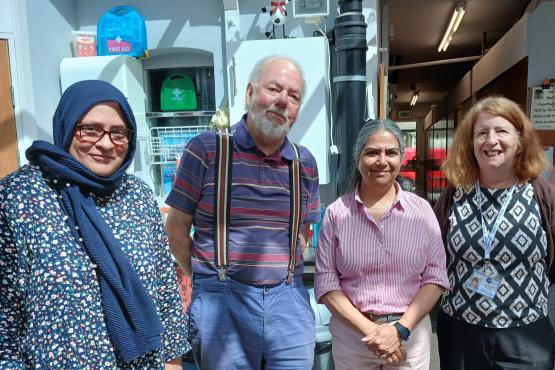 Image of four people standing together, 3 women and 1 man