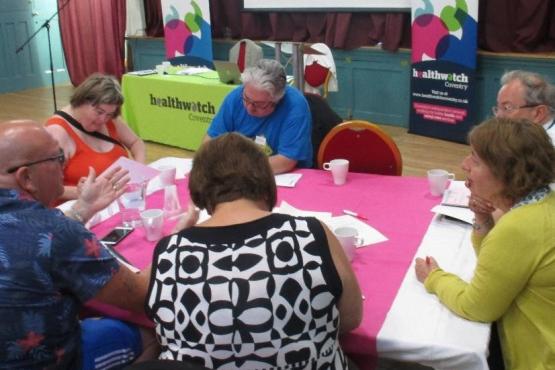 Round table of people talking at Healthwatch meeting