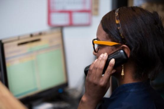 Black woman on phone in front of computer