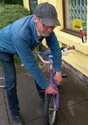 Man fixing a bike outside