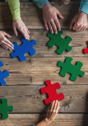 People sat round a table with giant jigsaw pieces